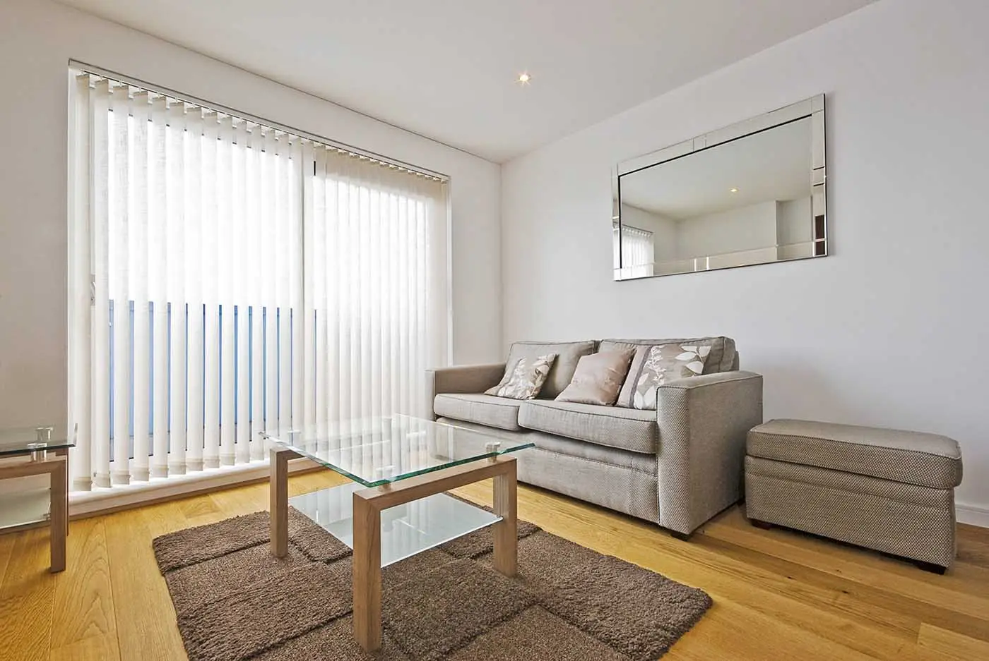White vertical blinds across sliding doors in a bright living room